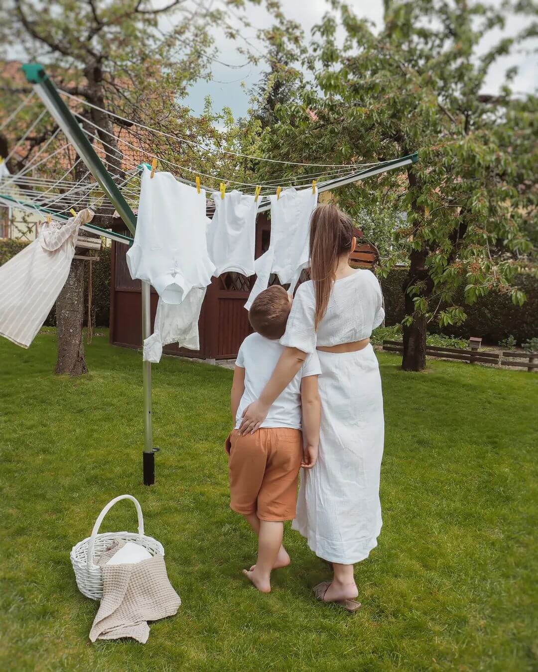 Case study LEIFHEIT influencer marketing zdjęcie przedstawia matkę z dzieckiem na tle białego prania wiszącego na suszarce w zielonym ogrodzie